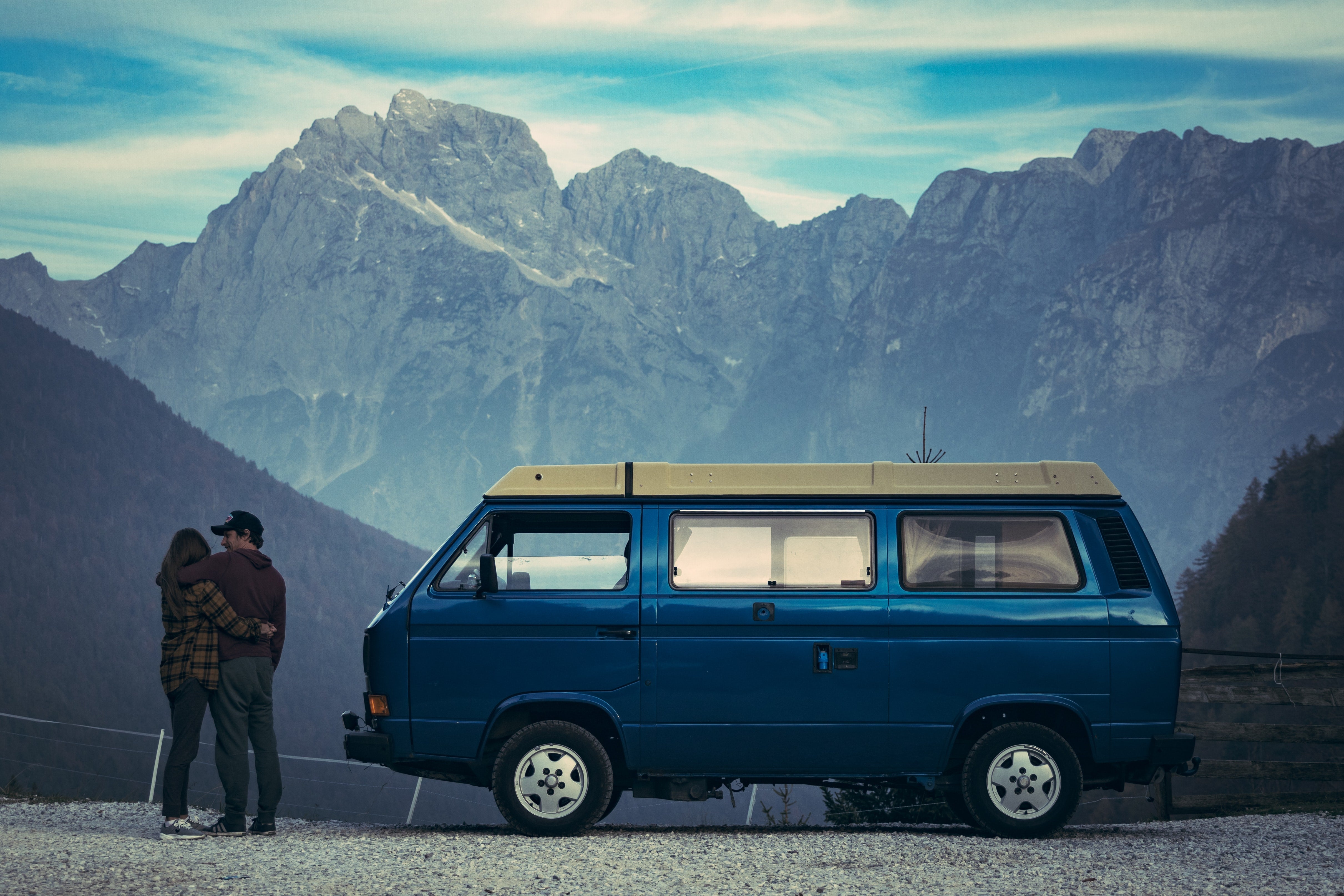 hipster van life couple embracing adventure beside westfalia van and mountains